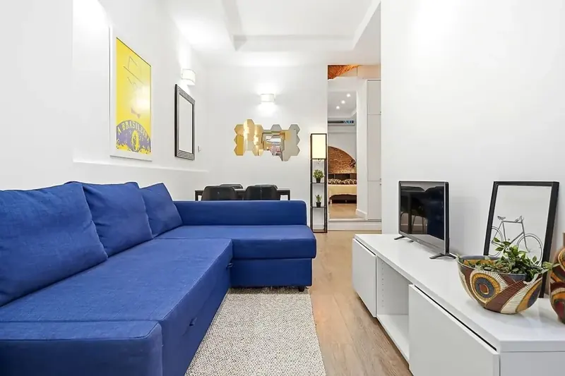Sala de um apartamento acabado de pintar, com sofá azul