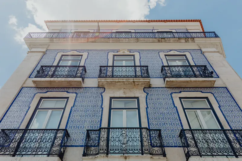 Fachada de azulejo azul em Lisboa vista de baixo, com varandas de ferro