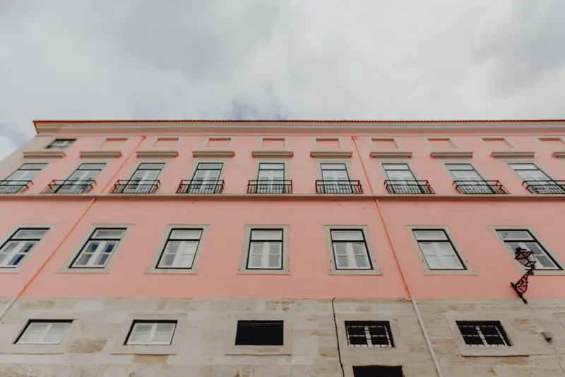 Fachada lisboeta cor-de-rosa, com janelas de cantaria e varandas de ferro