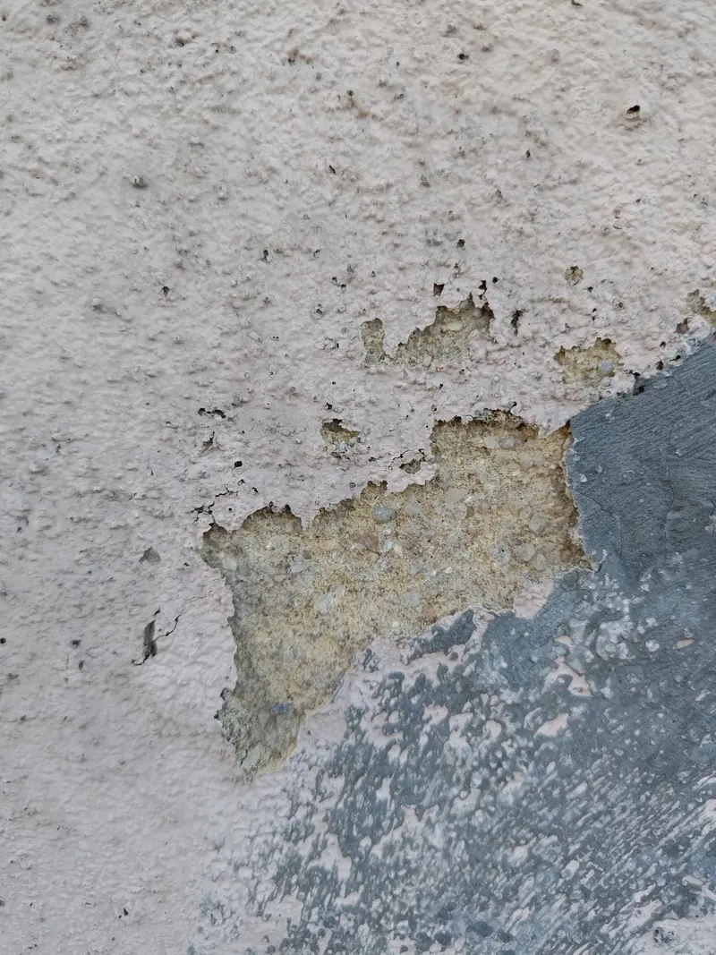 Reboco exterior com tinta a destacar e manchas de humidade