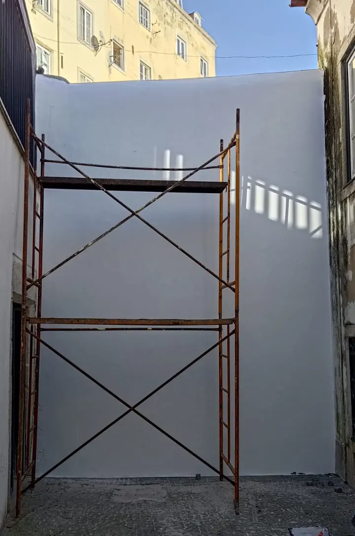 O mesmo muro pintado de branco, com a torre de andaime ainda montada
